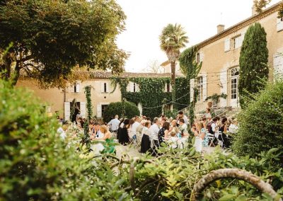 Shot through the greenery of the courtyard, this wedding group are enjoying their meal